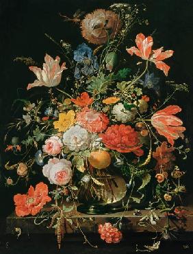 Ein Glas mit Blumen und Orangenzweig