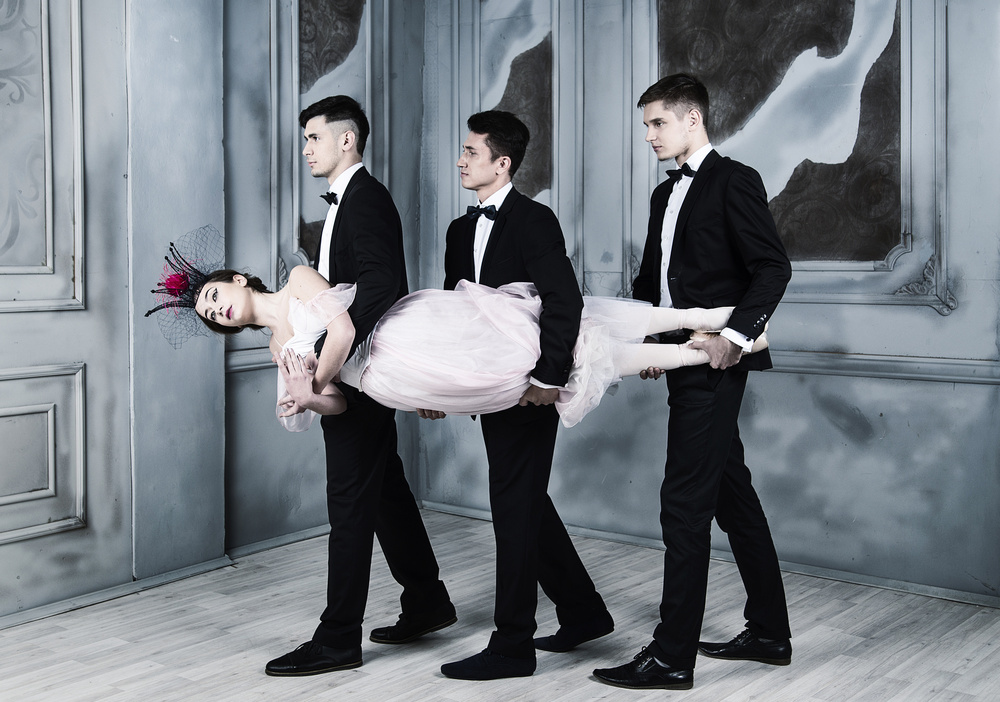 Trinity. three men in tuxedos carry a ballerina in their arms von Alexandr