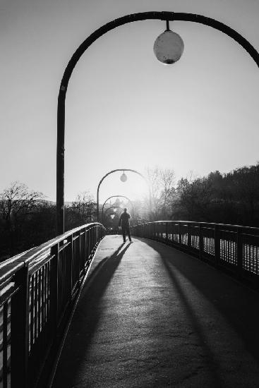 Man in backlight on a bridge