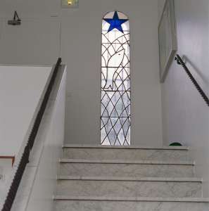 Entrance stairs to the Chapel of the Rosary with window depicting a fish caught in a net beneath the
