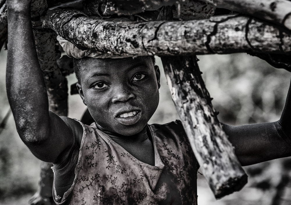 Somba tribe child carrying some wood - Benin von Joxe Inazio Kuesta Garmendia
