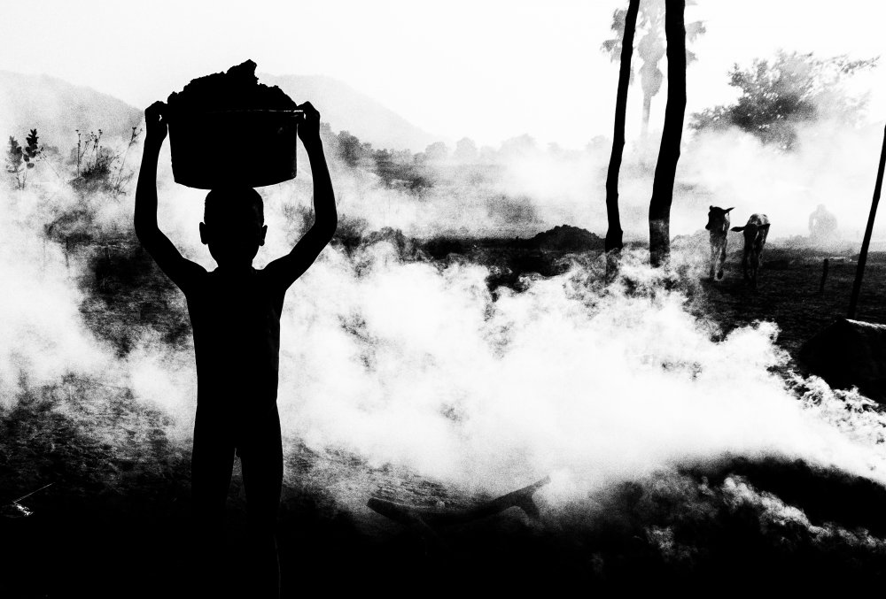 Carrying dung in a mundari cattle camp. von Joxe Inazio Kuesta Garmendia