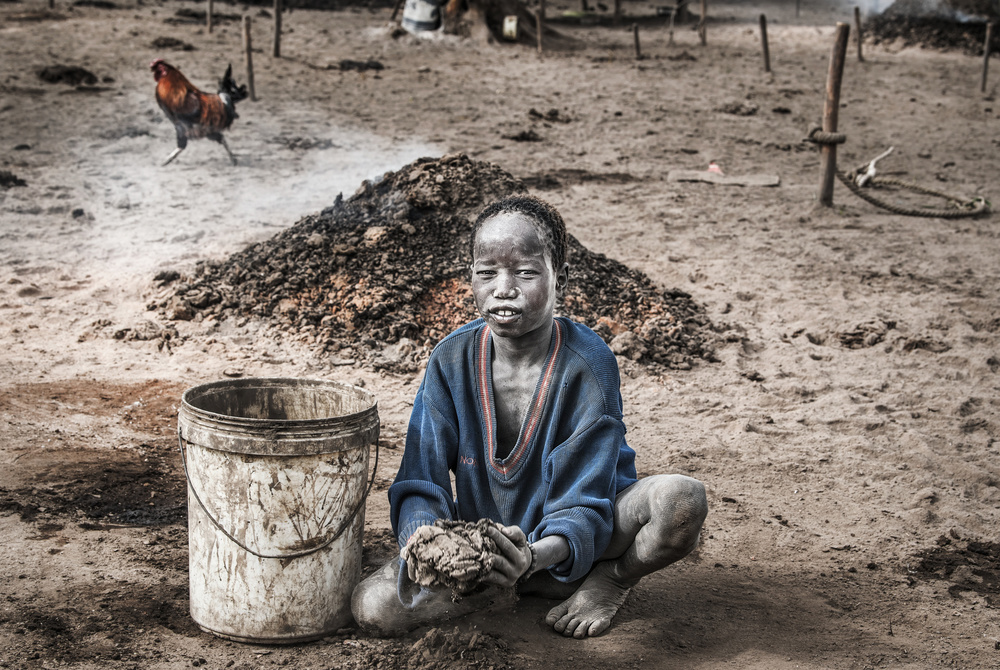 Mundari child collecting dung - South Sudan von Joxe Inazio Kuesta Garmendia