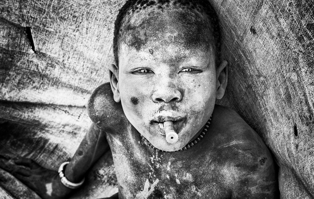 Mundari child playing with a bullet casing - South Sudan von Joxe Inazio Kuesta Garmendia