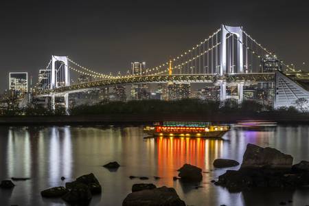 Prächtige Rainbow Bridge mit Tokio Skyline am Abend 