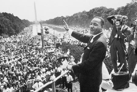 Martin Luther King American priest activist for Civil Right Movement of black Americans saluting the