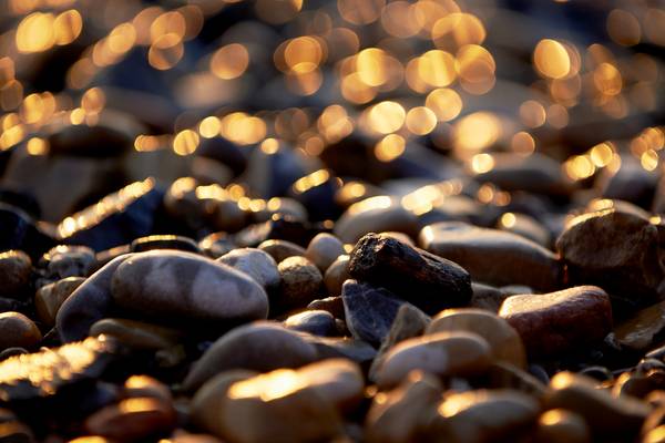 Glitzernd leuchtende Kieselsteine am Ufer der Donau von Robert Kalb