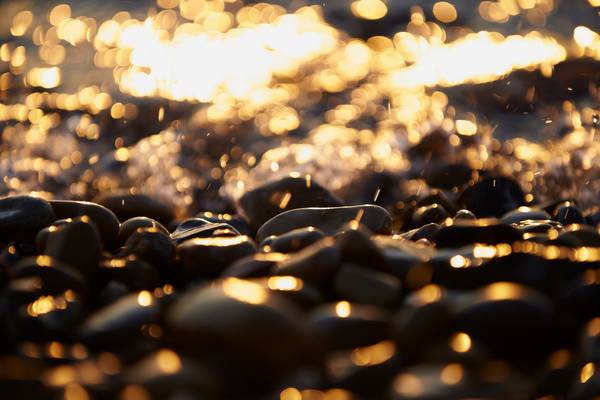 Glitzernd leuchtende Kieselsteine am Ufer der Donau von Robert Kalb