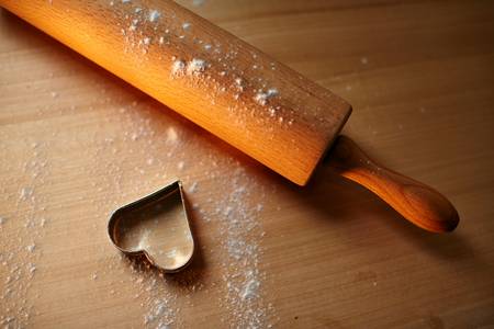 Herz-Ausstecher und Teigroller auf dem Tisch